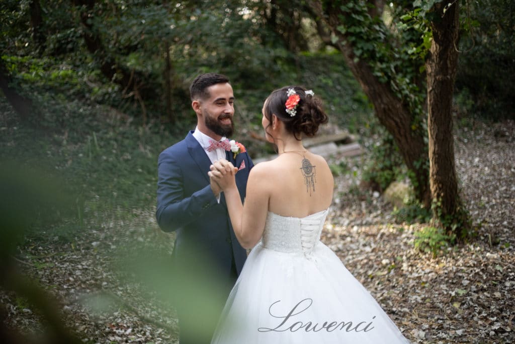 Deux beaux mariés dans une forêt, robe et costume, feuilles et couleurs automnales, arbres, tatouage, nœud papillon
